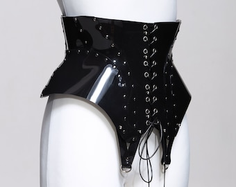 May include: A black patent leather corset with a lace-up front and metal accents. The corset has a pointed shape at the bottom and is designed to cinch the waist.