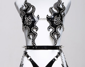 May include: Black leather lingerie set with a flame design and rhinestones. The set includes a bra, a belt, and a garter belt.