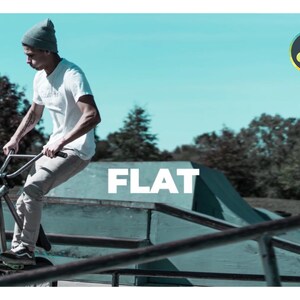 K&ouml;nnte beinhalten: Eine Person f&auml;hrt mit einem BMX-Rad in einem Skatepark. Die Person tr&auml;gt ein wei&szlig;es T-Shirt, eine graue Hose und eine graue M&uuml;tze. Das Wort "FLAT" wird in gro&szlig;en wei&szlig;en Buchstaben angezeigt. Der Hintergrund umfasst einen blauen Himmel und B&auml;ume.