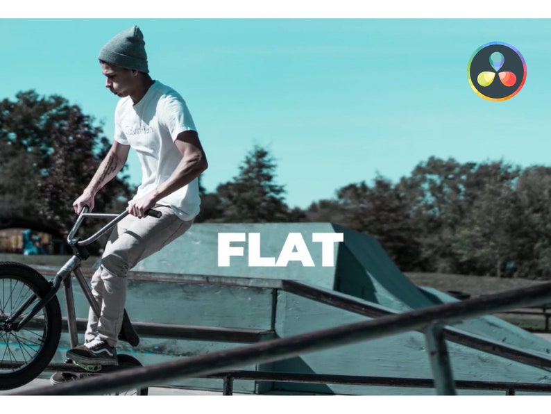 K&ouml;nnte beinhalten: Eine Person f&auml;hrt mit einem BMX-Rad in einem Skatepark. Die Person tr&auml;gt ein wei&szlig;es T-Shirt, eine graue Hose und eine graue M&uuml;tze. Das Wort "FLAT" wird in gro&szlig;en wei&szlig;en Buchstaben angezeigt. Der Hintergrund umfasst einen blauen Himmel und B&auml;ume.