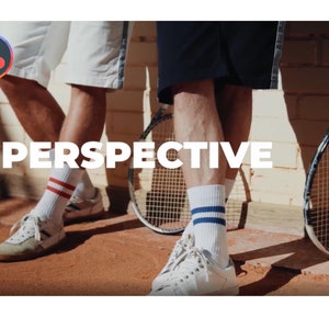 K&ouml;nnte beinhalten: Bild mit zwei Personen in Tennisbekleidung, mit Tennisschl&auml;gern und dem Wort "PERSPECTIVE" in wei&szlig;en Blockbuchstaben. Eine Person tr&auml;gt wei&szlig;e Shorts, wei&szlig;e Socken mit roten Streifen und wei&szlig;e Turnschuhe. Die andere tr&auml;gt marineblaue Shorts und wei&szlig;e Socken mit blauen Streifen.