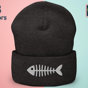 Op de afbeelding: Een zwarte beanie met een wit visgraatontwerp. De beanie is gemaakt van een zacht, comfortabel materiaal en heeft een omslag.