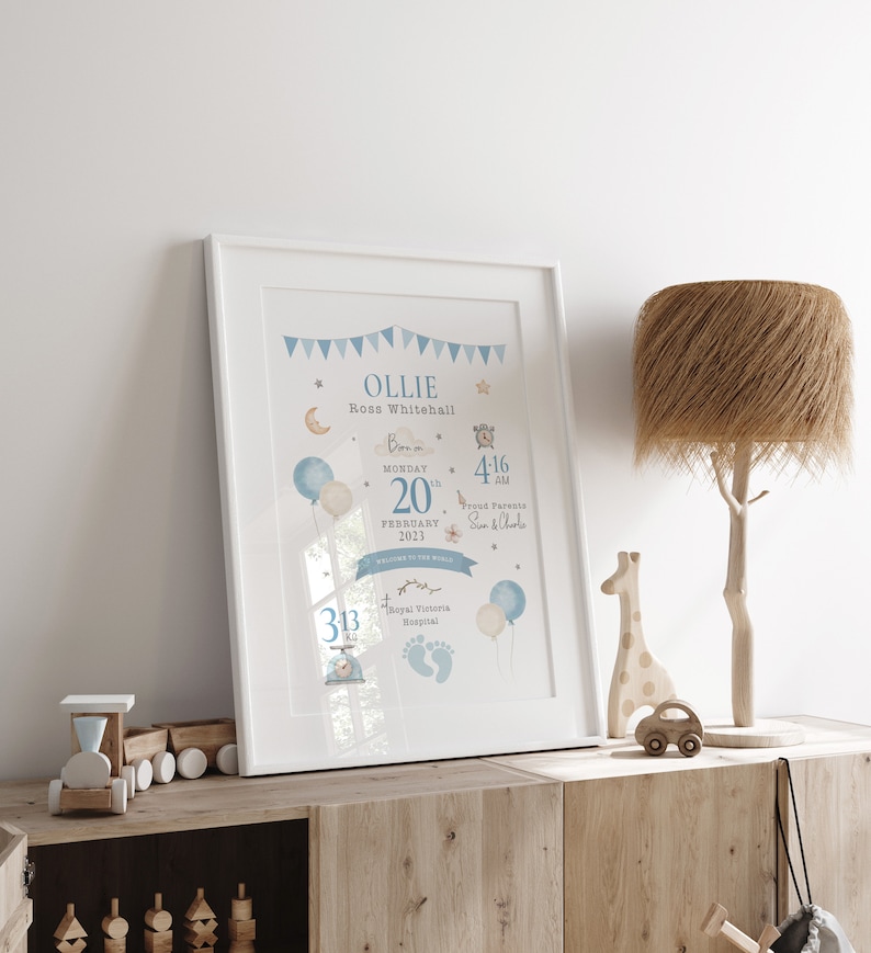 May include: A blue and white baby announcement print with the name Ollie Ross Whitehall, born on Monday, February 20th, 2023 at 4:16 AM. The print features a blue and white balloon, a star, a moon, and a clock. The print also includes the text "Proud Parents Sun & Charle" and "Royal Victoria Hospital".