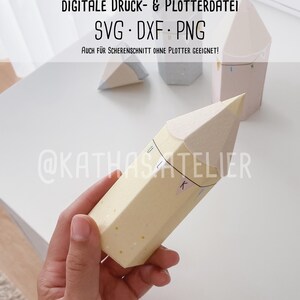 Op de afbeelding: Een gele papieren potlooddoos met witte stippen. De doos is gelabeld met de letters "L" en "K". De tekst "DIGITALE DRUCK- & PLOTTERDATEI SVG DXF PNG AUCH FÜR SCHERENSCHNITT OHNE PLOTTER GEEIGNET! @KATHASATELIER" is zichtbaar op de achtergrond.