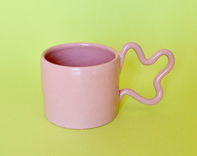 Handmade ceramic mug with wiggle handle design and pink glaze