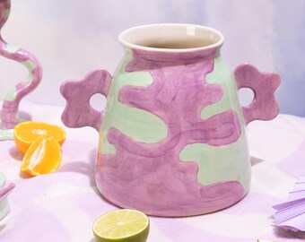 Jarrón de cerámica verde y morado hecho a mano con diseño de remolino pintado a mano y asas onduladas.