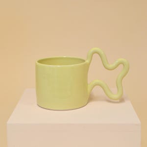 Buttery yellow handmade ceramic mug with wiggle handle