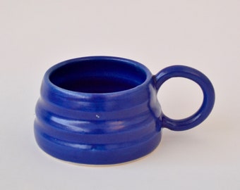 Blue handmade ceramic mug with wiggly ripple shape