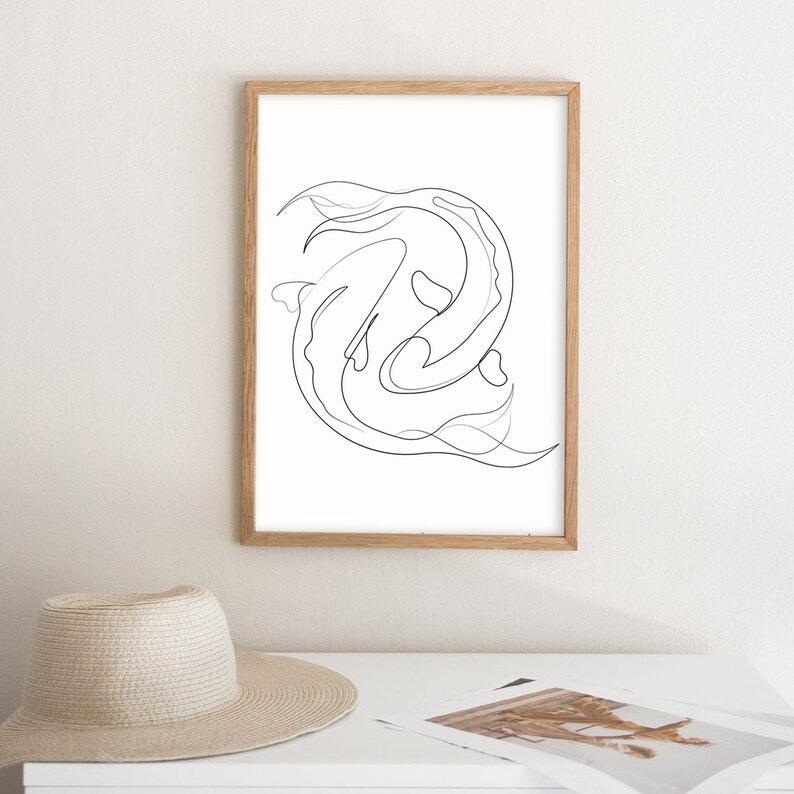 May include: A black and white line drawing of two fish swimming in a circle. The drawing is framed in a light wood frame and is hanging on a white wall.