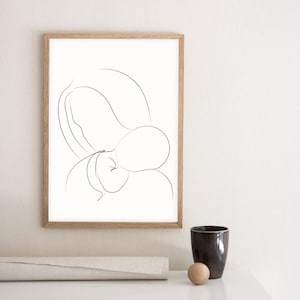 May include: A black and white line drawing of a mother and child in a minimalist style. The drawing is framed in a light wood frame and is hanging on a white wall.