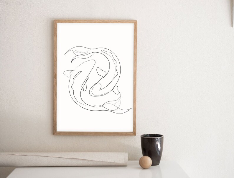 May include: A black and white line drawing of two fish swimming in a circle, framed in a light wood frame.