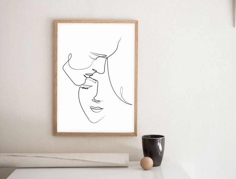 May include: A black and white line drawing of two faces, one above the other, in a minimalist style. The faces are drawn in a single continuous line.