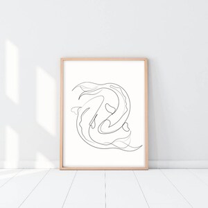 May include: A black and white line drawing of two fish swimming in a circle, framed in a light wood frame.