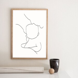 Puede incluir: Un dibujo en blanco y negro de una persona sosteniendo un beb&eacute;. El dibujo est&aacute; enmarcado en un marco de madera claro.