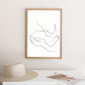 May include: A black and white line drawing of a parent holding a baby. The parent is kissing the baby on the forehead. The drawing is simple and elegant.