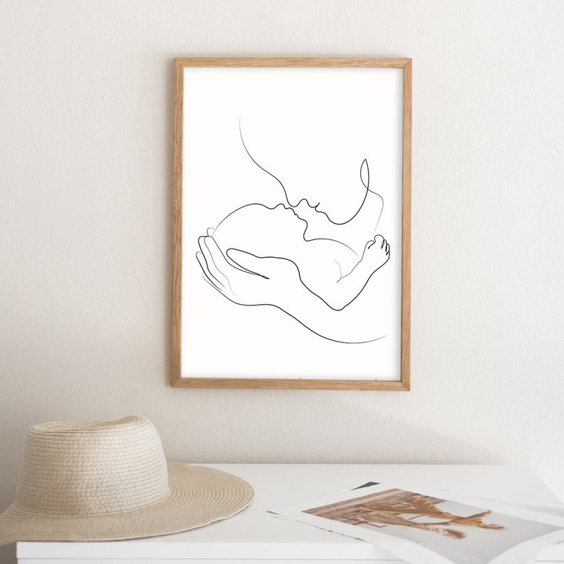 May include: A black and white line drawing of a parent holding a baby. The parent is kissing the baby on the forehead. The drawing is simple and elegant.