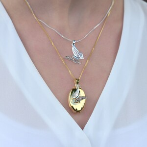 woman wearing gold oval Photo Necklace with silver butterfly charm