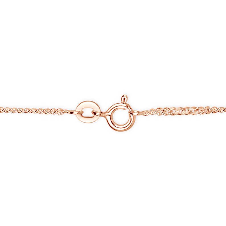Close-up of a rose gold curb chain clasp with a spring ring fastening and extension links.