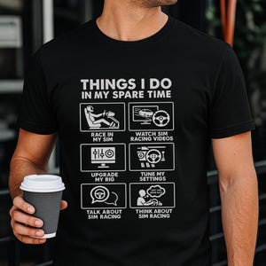 May include: Black t-shirt with white text and graphics. The text reads "THINGS I DO IN MY SPARE TIME" above six illustrations related to sim racing, including "RACE IN MY SIM" and "WATCH SIM RACING VIDEOS".