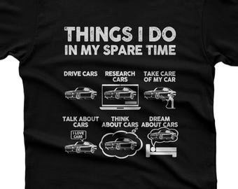 Könnte beinhalten: Ein schwarzes Kurzarm-T-Shirt mit dem weißen Text THINGS I DO IN MY SPARE TIME. Unter dem Text befinden sich sechs Auto-Illustrationen mit den Bildunterschriften: DRIVE CARS, RESEARCH CARS, TAKE CARE OF MY CAR, TALK ABOUT CARS, THINK ABOUT CARS und DREAM ABOUT CARS.