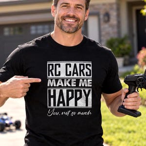Pode incluir: Uma t-shirt preta de manga curta com texto branco que diz RC CARS MAKE ME HAPPY You, not so much. A peça é feita de tecido preto sólido e exibe o design gráfico claramente na parte frontal, no centro da área do peito.