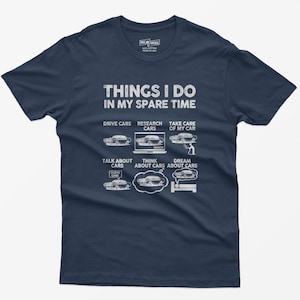 May include: A navy blue t-shirt with white text that reads "Things I do in my spare time". The text is divided into six sections, each with a car-related activity: "Drive Cars", "Research Cars", "Take Care of My Car", "Talk About Cars", "Think About Cars", and "Dream About Cars". Each section has a small illustration of a car.