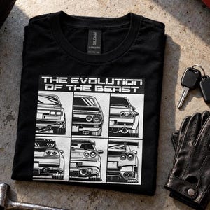 Może przedstawiać: Czarny t-shirt z okrągłym dekoltem i białym nadrukiem graficznym z napisem THE EVOLUTION OF THE BEAST. Wzór przedstawia sześć ilustracji samochodów sportowych widzianych od tyłu, ułożonych w siatkę, ukazujących różne światła i wydechy.