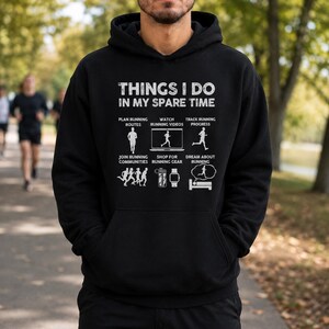 May include: A black hooded sweatshirt featuring white text that reads THINGS I DO IN MY SPARE TIME. Below the text are six icons with labels: PLAN RUNNING ROUTES, WATCH RUNNING VIDEOS, TRACK RUNNING PROGRESS, JOIN RUNNING COMMUNITIES, SHOP FOR RUNNING GEAR, and DREAM ABOUT RUNNING.