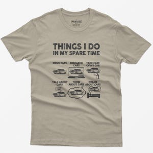 May include: A beige t-shirt with a black graphic that says "Things I do in my spare time" and lists activities related to cars. The activities include driving cars, researching cars, taking care of a car, talking about cars, thinking about cars, and dreaming about cars.