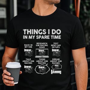 May include: A black short-sleeved t-shirt featuring white text that reads THINGS I DO IN MY SPARE TIME followed by six illustrations depicting sim racing activities including racing, researching gear, testing setups, talking, thinking, and dreaming.
