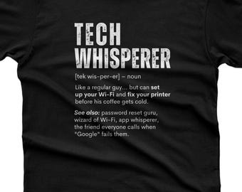 May include: A black short-sleeved t-shirt featuring white text that reads TECH WHISPERER, followed by a dictionary-style definition describing someone who sets up Wi-Fi and fixes printers, along with related terms like password reset guru.