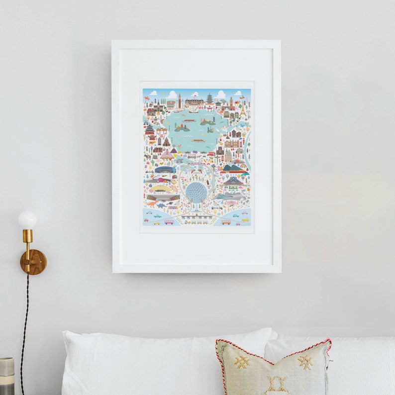 May include: A framed print of a colorful illustrated map of the world with landmarks and icons representing different cities and countries. The map is surrounded by a white frame.