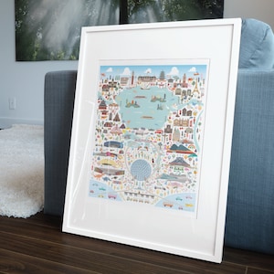 May include: A white framed print of a colorful illustrated map of a city. The map features buildings, landmarks, and transportation. The map is surrounded by a white border.