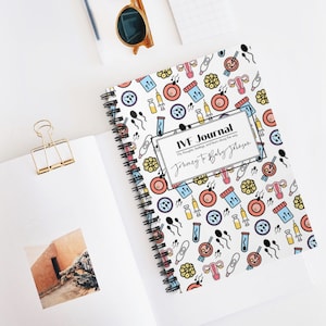 May include: A white spiral bound journal with a colorful pattern of IVF related icons. The cover has the text "IVF Journal" and "Journey to Baby Johnson".