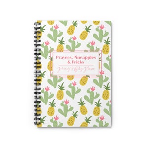 May include: A white spiral bound notebook with a pineapple and cactus pattern. The text on the cover reads "Prayers, Pineapples & Pricks Journey to Baby Johnson".