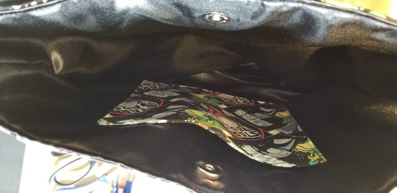 May include: Black tote bag with a black satin lining and a colorful patterned pocket inside.