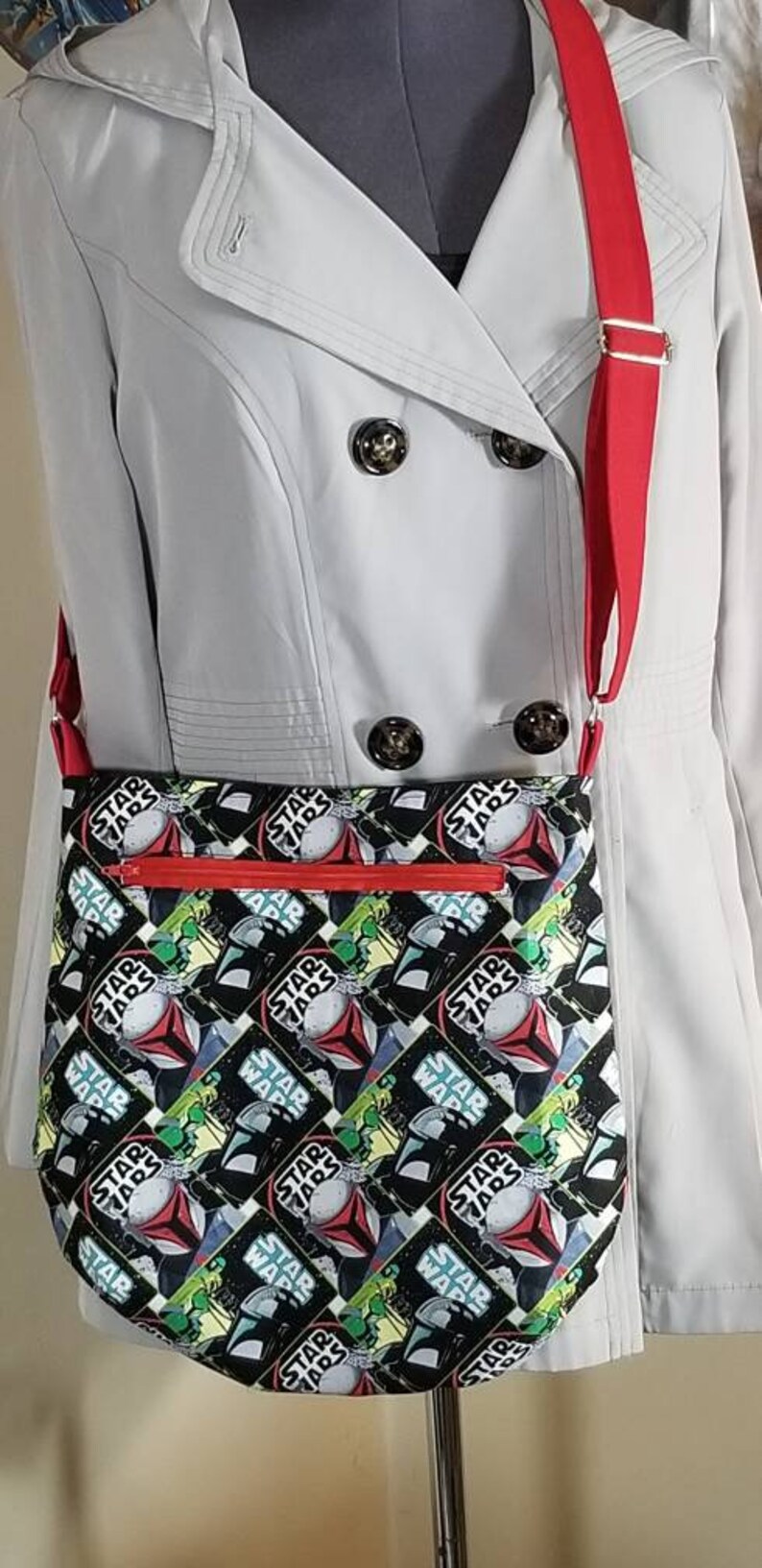 May include: A red and white crossbody bag with a black and white Star Wars print featuring the text "Star Wars" repeated throughout the design.