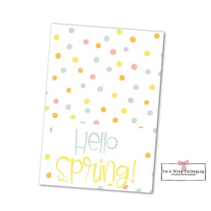 Puede incluir: Una etiqueta rectangular blanca con lunares pastel en naranja, amarillo, rosa y azul. Las palabras "Hello Spring!" están escritas en escritura azul claro y amarillo. La etiqueta es para el embalaje de galletas.