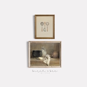 May include: Two framed prints with a vintage aesthetic. The top print features a watercolour illustration of three silver ladles. The bottom print shows a still life of a black pot, a white bowl, a ceramic pitcher, and a copper teapot on a wooden table.