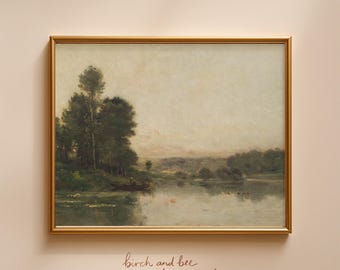 May include: A framed landscape painting featuring a calm lake, a small boat with a figure, and dense green trees under a soft, muted sky. The artwork is enclosed in a thin gold frame. Below the frame, the text reads birch and bee prints.