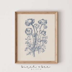 Puede incluir: Una ilustraci&oacute;n bot&aacute;nica de estilo vintage de un ramo de flores azules con tallos y hojas. La ilustraci&oacute;n est&aacute; sobre un fondo crema y enmarcada en un marco de madera claro.