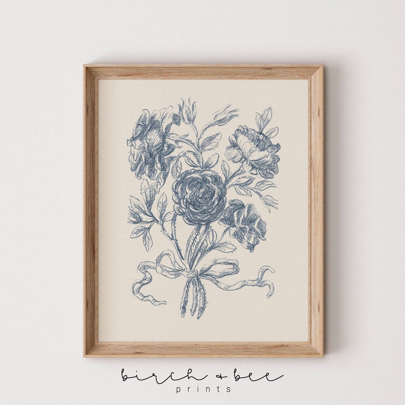Puede incluir: Una impresi&oacute;n floral vintage azul y blanca con un ramo de rosas atado con una cinta. La impresi&oacute;n est&aacute; en un marco de madera.