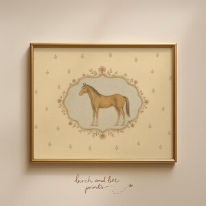 May include: A framed print featuring a tan horse illustration centered within an ornate, floral-bordered oval medallion. The background is a cream-colored paper with a repeating small flower pattern. The text "birch and bee prints" is below.
