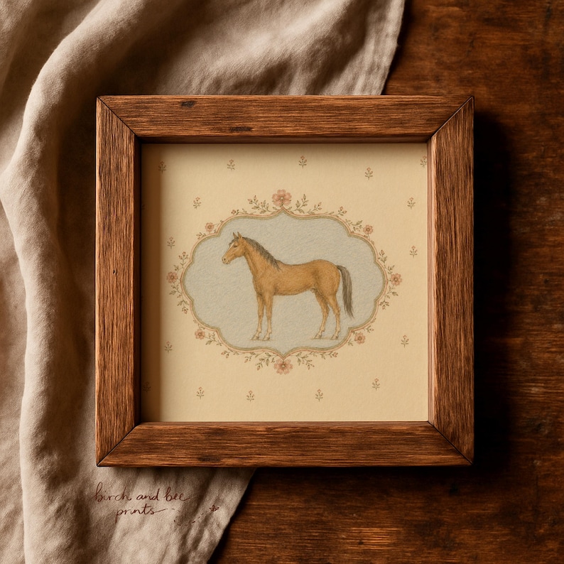 May include: A square wooden frame containing a print of a light brown horse standing in profile. The horse is centered within an ornate, scalloped border featuring small pink flowers against a cream background with a repeating floral pattern.