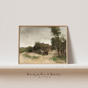 May include: A painting of a rural scene with a small cottage, a horse-drawn cart, and figures in the foreground. The sky is cloudy and the trees are green. The painting is framed in a light wood frame.