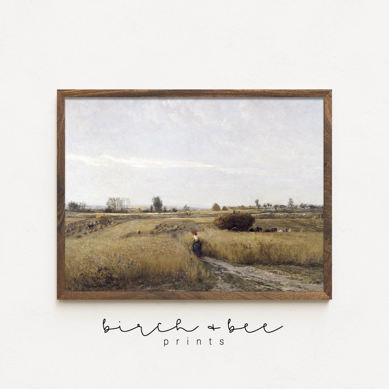 May include: A vintage painting depicting a rural landscape with a field of wheat, a dirt road, and a lone figure walking in the distance. The sky is overcast with a light blue hue. The painting is framed in a brown wooden frame.