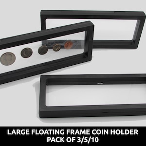 Könnte beinhalten: Drei schwarze, rechteckige Münzrahmen mit transparenten Sichtfenstern. Ein Rahmen enthält mehrere Münzen. Der Text unten lautet "LARGE FLOATING FRAME COIN HOLDER PACK OF 3/5/10".