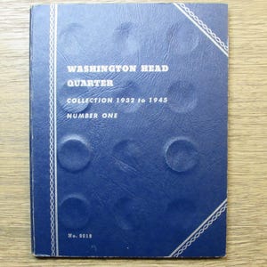 May include: A blue coin collection album titled "Washington Head Quarter Collection 1932 to 1945 Number One." The album has a textured surface with circular indentations and a white decorative border.