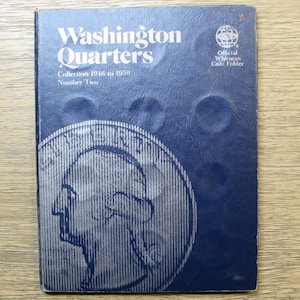 May include: A blue coin folder titled "Washington Quarters" with the text "Collection 1946 to 1959 Number Two." The cover features a large silver illustration of a quarter and the words "Official Whitman Coin Folder."