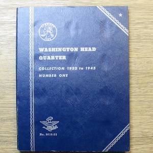 May include: A blue coin collection album titled "Washington Head Quarter Collection 1932 to 1945 Number One." The cover features a silver emblem and text, with a decorative border. The album is closed and in good condition.